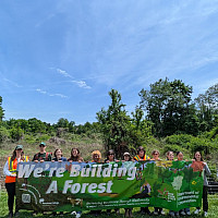 We're building a forest! Students, faculty, and staff holding a banner as we broke ground for the Commons Experimental Forest