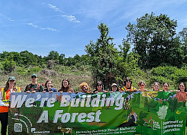 Many people holding a banner that says We're building a forest