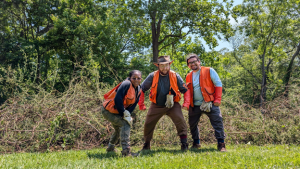   Corey standing in front of a pile of removed invasives 