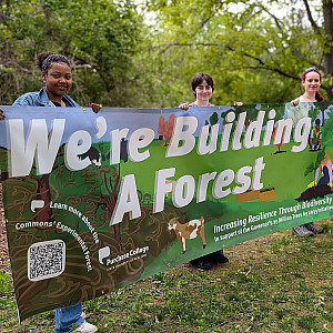 Students holding a banner that reads We're building a forest
