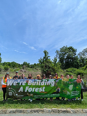 We're building a forest! Students, faculty, and staff holding a banner as we broke ground for the Commons Experimental Forest