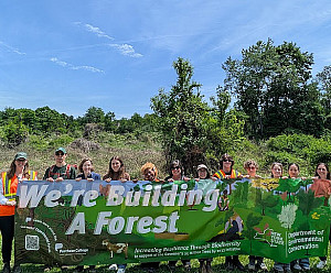 Many people holding a banner that says We're building a forest