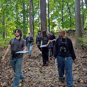 2024 Wildlife Ecology students learning about phenology from Dr. Hanna Makowski in the campus woods