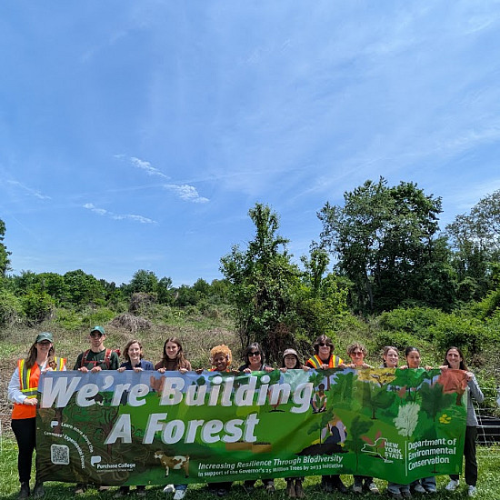 We're building a forest! Students, faculty, and staff holding a banner as we broke ground for the Commons Experimental Forest