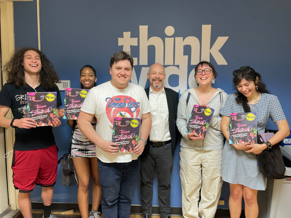 Students hold the latest issue of The Beat with Professor of Journalism Andrew Salomon. Pictured ...