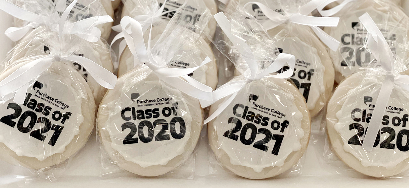 White cookies with Class of 2020 and 2021 in black wrapped in cellophane with white bows.