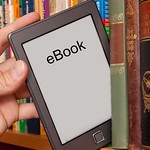 eBook reader is being shelved next to print books.