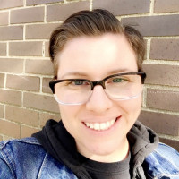 photo of Marie Sciangula standing outside against a brick background.