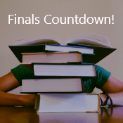 It's Finals Countdown! Student hides behind a pile of library books.