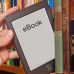 eBook reader is being shelved next to print books.