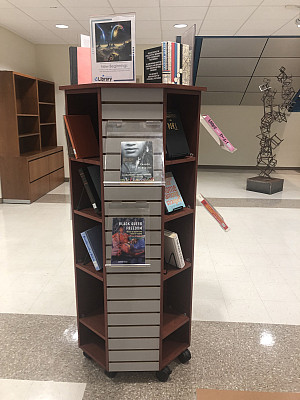 Books on Afrofuturism, migration, and change are displayed on a shelf at the Library