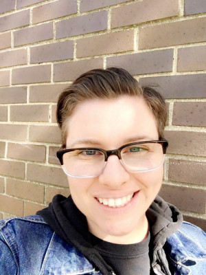 photo of Marie Sciangula standing outside against a brick background.