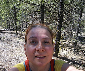 woman standing in the woods in athletic attire