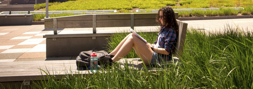 A student reading papers outside