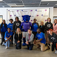 Group of students and administrators posing with school mascot