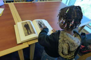 Jordin Faison, 7, From Port Chester examines and art book in the Library.